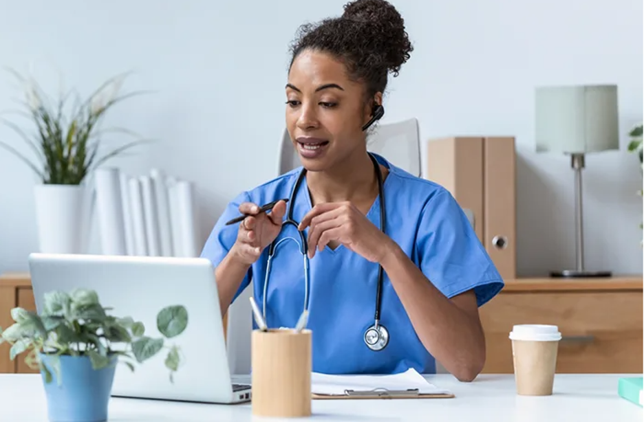 Female nurse talking to patient through the computer.