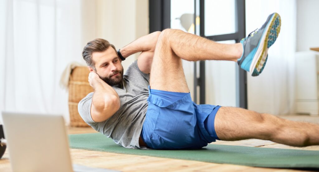 Bearded young man doing abs exercise at home