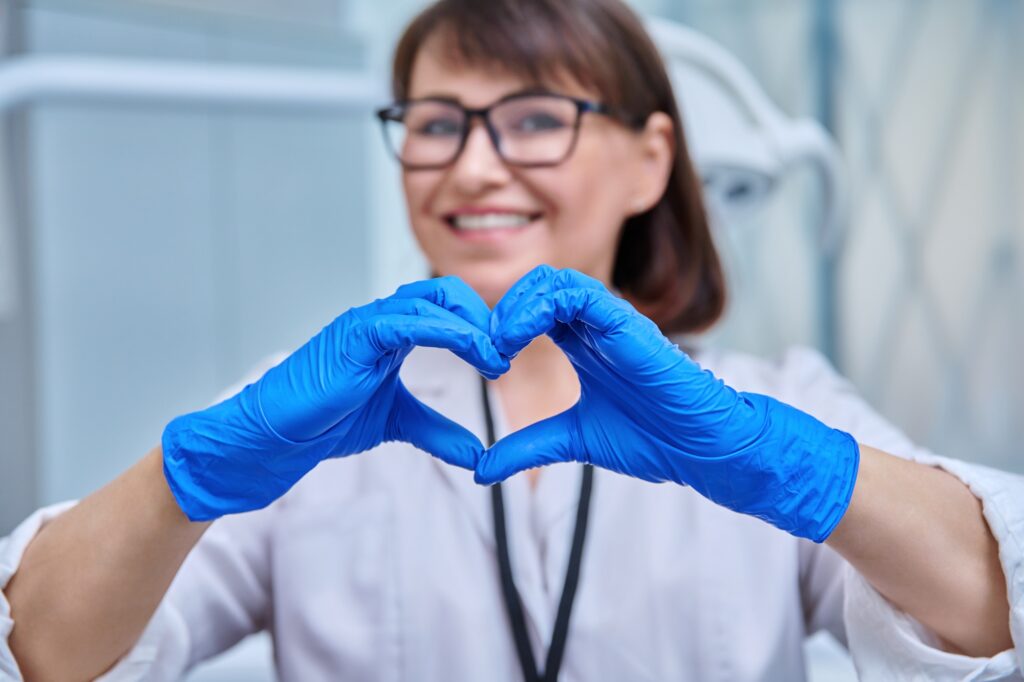 Close-up of heart sign symbol shown by nurse doctor