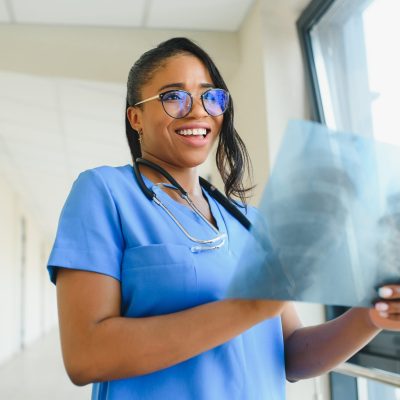 african doctor looking at patients x-ray at hospital #image_title